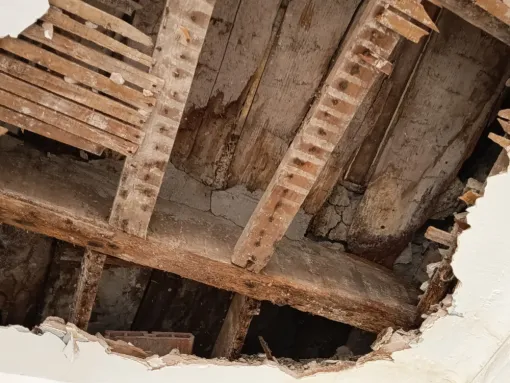Ouverture d'un faux-plafond. Présence d'enfustages bois cassés et de pourrissement des appuis des poutres en bois.